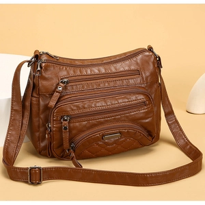 Close-up of brown soft leather shoulder bag featuring multiple functional front zippers