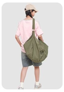 Detail of green and brown checkered canvas hobo bag with metal ring shoulder attachment