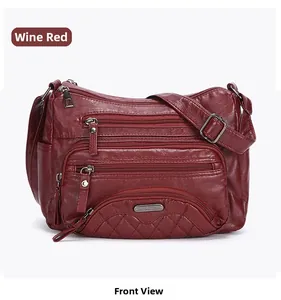 Detail view of burgundy washed leather shoulder bag with quilted pattern and zippers
