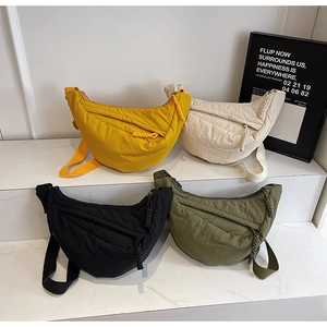 Dettaglio di quattro borse a mezzaluna in nylon giallo, beige, nero e verde militare