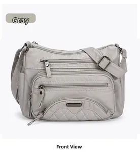 Front detail of grey washed PU leather crossbody bag featuring multiple zipper pockets
