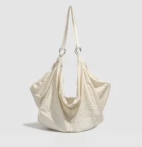 Detailed back view of beige water-resistant crossbody bag featuring vertical pleated texture