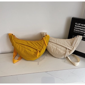 Detail of minimalist nylon crossbody bags in yellow and beige with adjustable straps