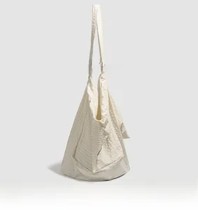 Side view of beige water-resistant tote bag with textured waffle grid fabric