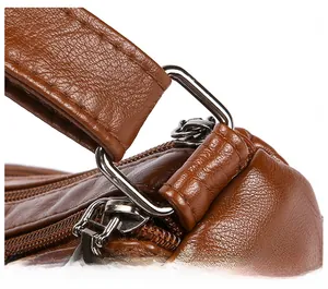 Detailed close-up of brown litchi grain leather bag with durable silver D-ring hardware