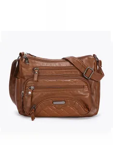 Detailed view of brown soft leather crossbody bag with multiple zippers and quilted base