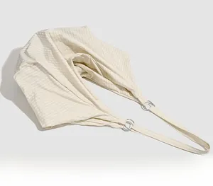 Detailed close-up of light beige quilted fabric and silver ring buckle on shoulder bag