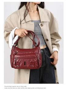 Detail of burgundy washed leather crossbody bag showing multiple zippers and quilted pattern