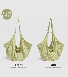 Detail of light green pleated nylon shoulder bag showing side and front texture