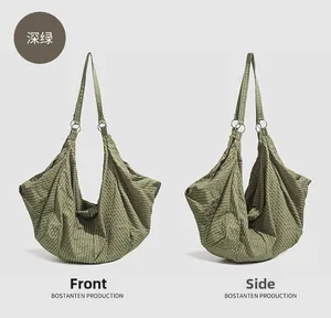 Detail of dark green pleated nylon shoulder bag showing dual front and side perspectives