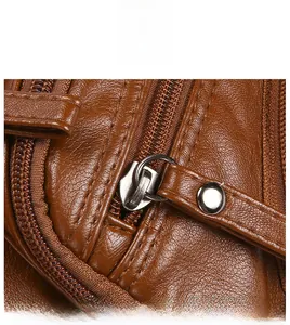 Detailed macro view of brown lychee grain leather with smooth silver metal zipper closure