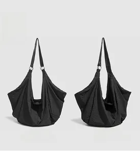 Detail of black nylon tote bag showing grid texture and silver metal ring hardware