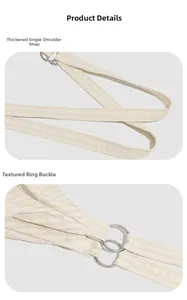 Detail of thickened shoulder strap and silver metal buckle on the cream nylon bag