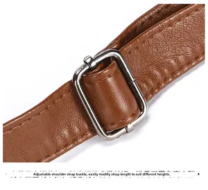 Detail of brown litchi grain leather strap with adjustable silver metal buckle on bag