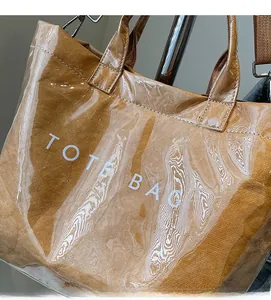 Detail of large tote bag with brown textured interior and transparent PVC waterproof outer