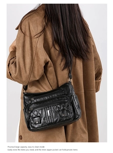 Detailed view of black washed leather crossbody bag with quilted pattern on a model