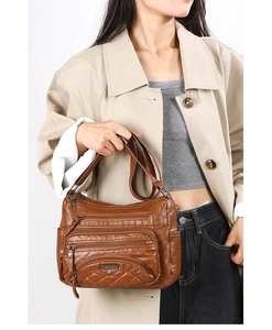 Detail of brown soft leather shoulder bag with multiple zippers and quilted texture