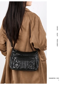 Detail of multi-zipper black cowhide crossbody bag with elegant quilted pattern on soft leather