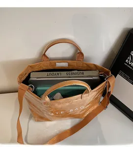 Top view of large brown tote bag showing spacious interior with laptop and books inside