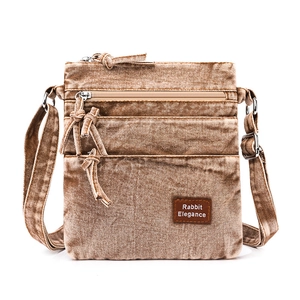 Detail view of vintage tan washed canvas crossbody bag with multiple zip pockets