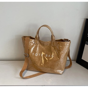 Detail of brown tote bag featuring wrinkled texture and white TOTE BAG printing