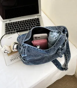 Vista dettagliata dello spazioso scomparto interno di questa borsa a tracolla in denim
