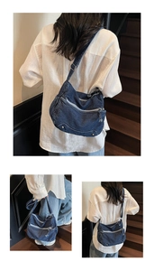 Dettaglio borsa a tracolla in denim blu con tasche multiple a zip e borchie metalliche
