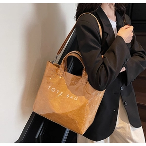 Detail of vintage brown tote bag with glossy texture and white TOTE BAG lettering print