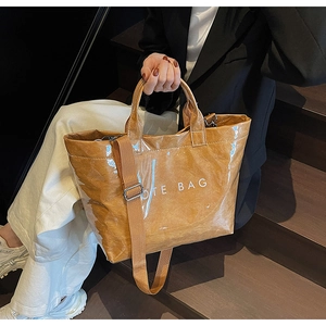 Detail of waterproof brown tote bag with TOTE BAG print and dual handle design