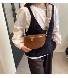 Detailed view of brown moon waist bag with golden zippers and wide woven strap on model