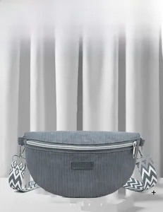 Détail du sac ceinture en velours côtelé gris avec bandoulière et logo en cuir
