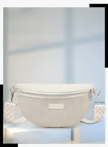 Détail du sac banane en velours côtelé blanc avec étiquette et bandoulière