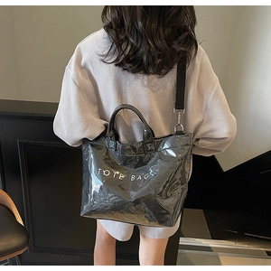 Fashionable black patent leather tote bag shown with shoulder strap for daily commuting