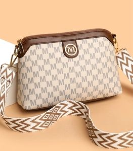 Detail of crossbody bag with M-pattern jacquard and gold logo on geometric stones