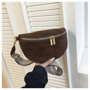 Detail of dark brown matte leather waist bag with bohemian embroidered wide strap and zippers