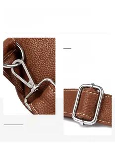 Detailed view of silver metal buckles and carabiners on a brown lychee leather bag strap