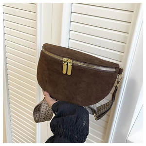 Detail of dark brown suede crescent belt bag with gold zippers and vintage woven strap