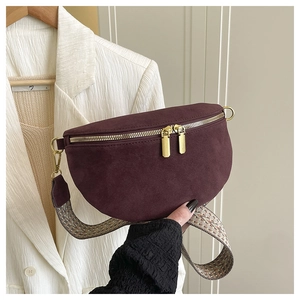 Detail of burgundy suede crescent bag featuring vintage bohemian woven shoulder strap