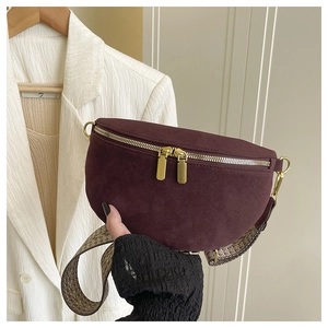 Close-up of burgundy suede waist bag with gold zippers and jacquard woven strap