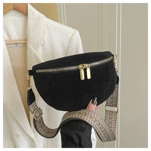 Detail of black suede crescent bag with dual gold zippers and vintage ethnic strap