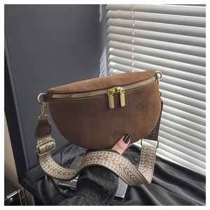 Detail of brown suede crescent waist bag with ethnic geometric strap and gold dual zippers