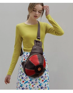 Detail of spherical basketball shaped crossbody bag in brown and red pebble leather