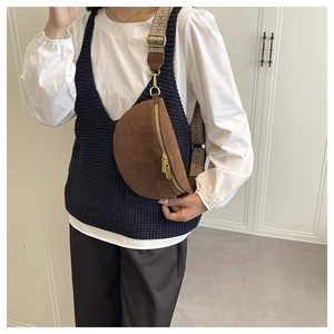 Detail of brown suede crossbody chest bag with vintage pattern jacquard strap