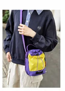 Outdoor lifestyle view of a purple and yellow nylon drawstring bucket bag with shoulder strap