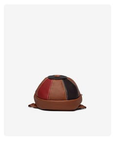 Close-up of baseball cap shaped bag showing stitching detail and lychee leather texture