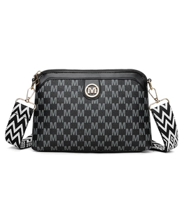 Detail of vintage patterned crossbody bag featuring gold M-logo and geometric strap