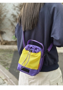Detail of a purple and yellow nylon crossbody water bottle bag with drawstring closure