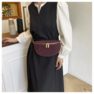 Detail view of burgundy suede waist bag featuring premium gold dual zippers and smooth texture