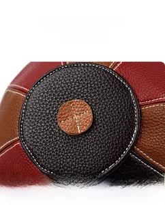 Macro detail of tricolor patchwork leather bag with textured lychee grain and contrast stitching