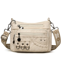 Close-up of beige multi-pocket canvas crossbody bag with ethnic patterned strap details